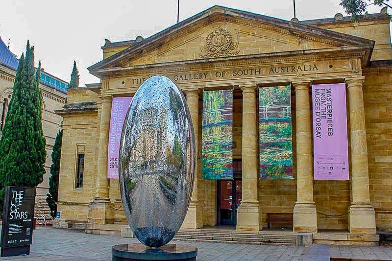 A large metal sculpture in front of a building.