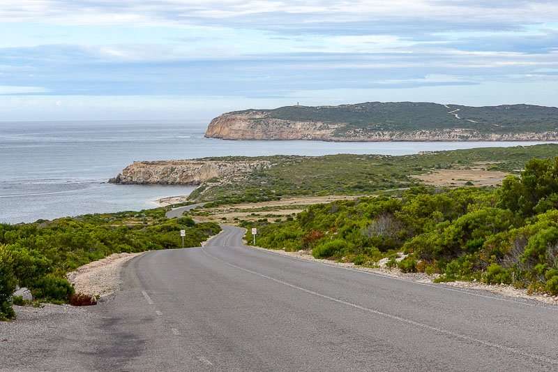 A scenic road leading to the ocean with a majestic cliff in the background, offering breathtaking views for places to visit in South Australia.