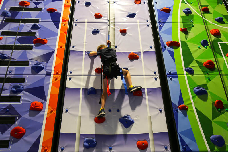 A boy climbing up an artificial climbing wall